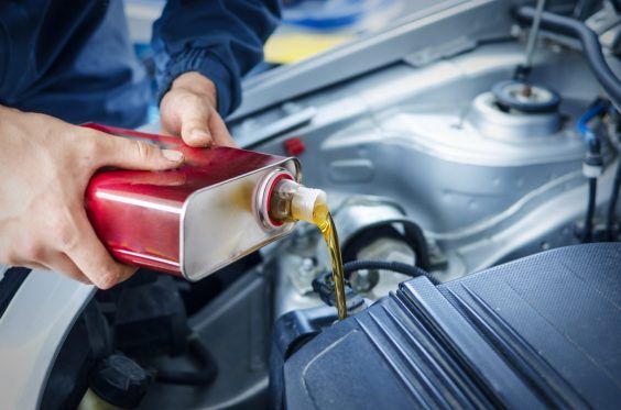 Cambio de aceite Mechanic changing engine oil on car vehicle.